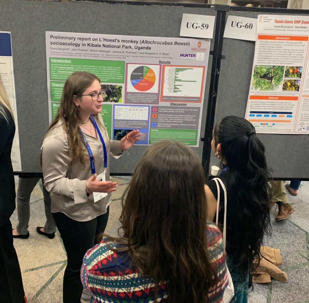 One white woman with brown hair explaining her scientific poster to two people