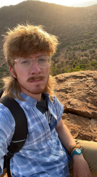 white man with red hair on rocky hill